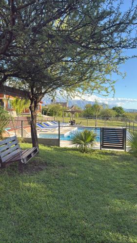 een park met een boom en een zwembad bij Cabañas AdamiS in Villa Cura Brochero