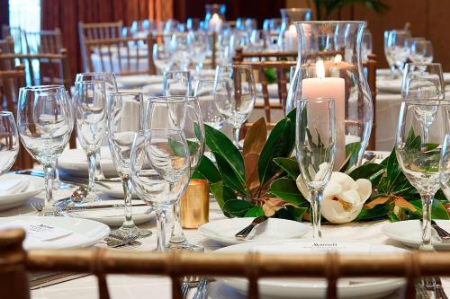 a table with wine glasses and a candle on it at Montgomery Marriott Prattville Hotel & Conf Ctr at Capitol Hill in Prattville
