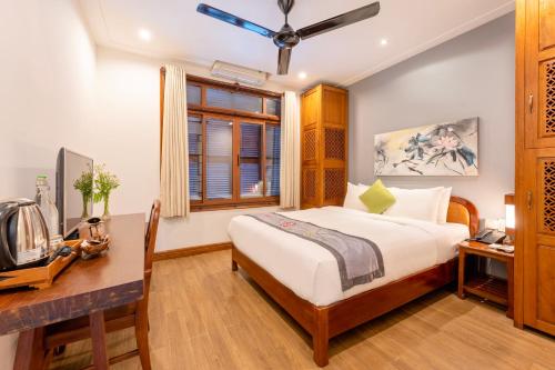 a bedroom with a bed and a desk at Thanh Van 1 Hotel in Hoi An