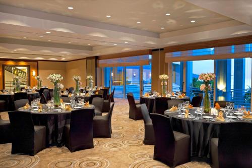a banquet room with tables and chairs and windows at The Westin Resort Guam in Tumon