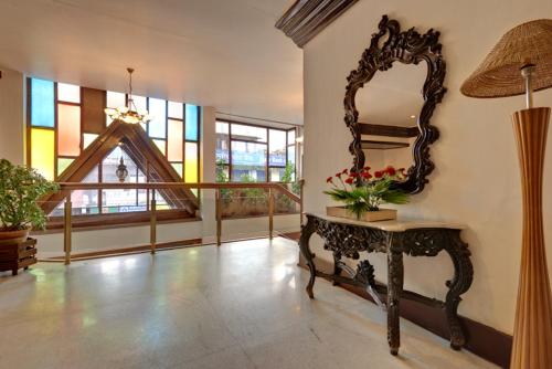 a room with a mirror and a table with flowers on it at Hotel Centre Point in Shillong