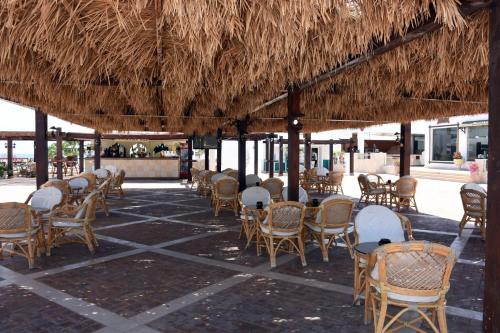 a group of tables and chairs under a straw umbrella at Sharm Club Beach Resort in Sharm El Sheikh
