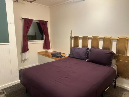 a bedroom with a bed with purple sheets and a window at West River House in Truckee