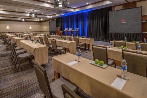 a row of tables and chairs in a room with a screen at Fullerton Marriott at California State University in Fullerton