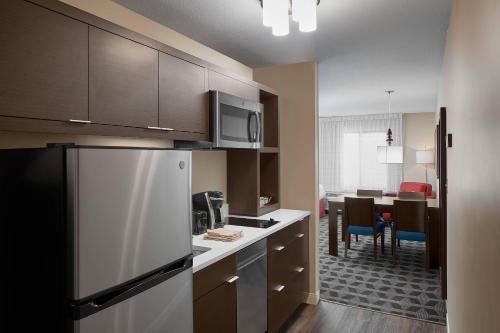 a kitchen with a refrigerator and a dining room at TownePlace Suites by Marriott Danville in Danville
