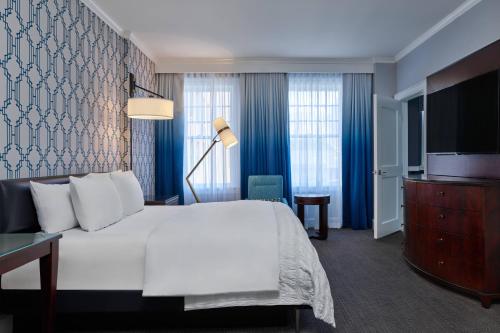 a hotel room with a bed and a television at Le Meridien Dallas, The Stoneleigh in Dallas