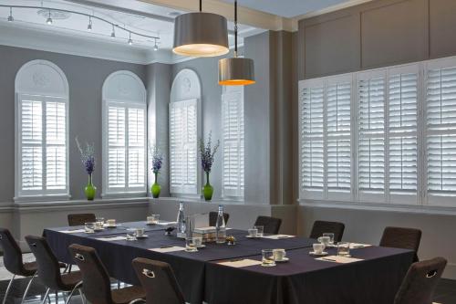 a meeting room with a table and chairs and windows at Le Meridien Dallas, The Stoneleigh in Dallas