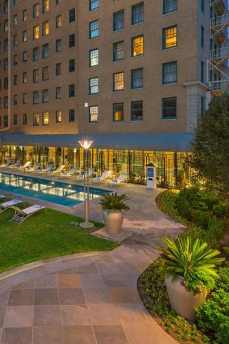 a hotel with a pool in front of a building at Le Meridien Dallas, The Stoneleigh in Dallas