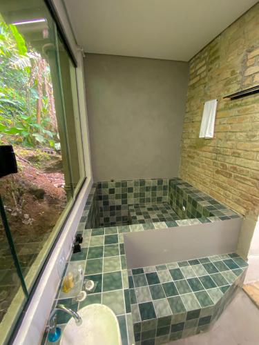 a bathroom with a shower with a tiled floor at Frente ao Mar - Suites com Piscina Aquecida, SPA Privativo, Vista ao Mar ou Montanha, com Estacionamento- Raizes do Mar ECO Hotel in Guarujá