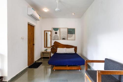 a bedroom with a blue bed in a room at Jungle stay by Bilwa Estate in SanivÄrsante