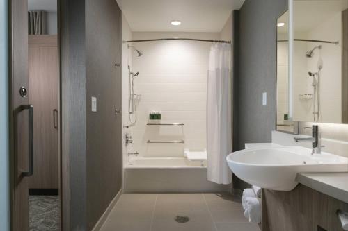 a bathroom with a tub and a sink and a shower at SpringHill Suites by Marriott Texas City in Texas City