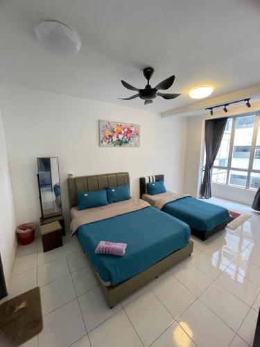a bedroom with two beds and a ceiling fan at Amy Homestay in Brinchang