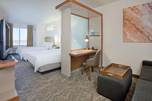 ein Hotelzimmer mit einem Bett und einem Schreibtisch in der Unterkunft Springhill Suites by Marriott Wichita East At Plazzio in Wichita