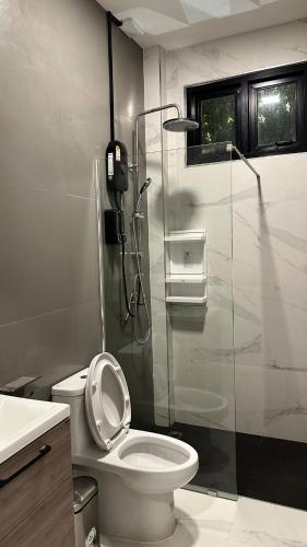 a bathroom with a toilet and a glass shower at Alisto Khaoyai in Wangkata