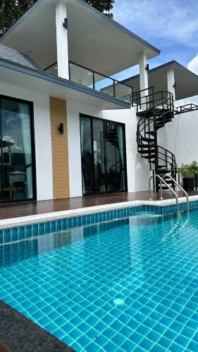 a house with a swimming pool next to a building at Alisto Khaoyai in Wangkata