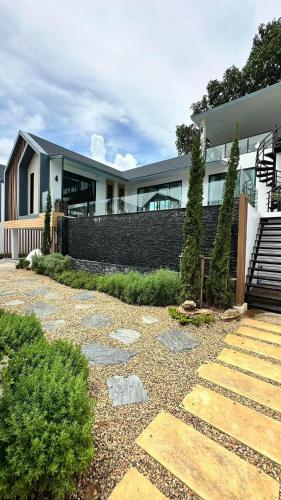a house with a stone pathway in front of it at Alisto Khaoyai in Wangkata