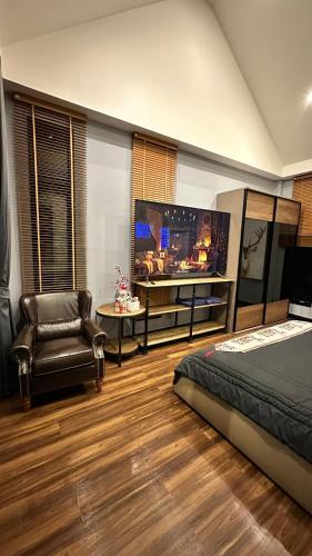 a bedroom with a bed and a tv and a chair at Alisto Khaoyai in Wangkata