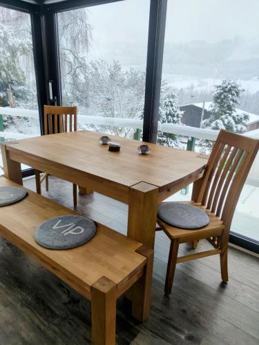 a wooden table and chairs in a room with a window at Ferienhaus Bergblick Urlaub mit Hund in Meschede
