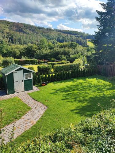 a garden with a small shed in the middle at Ferienhaus Bergblick Urlaub mit Hund in Meschede