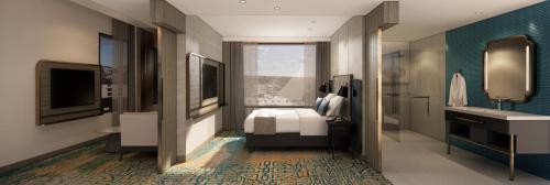 a bedroom with a bed and a bathroom with a sink at Mercure Madiun in Madiun