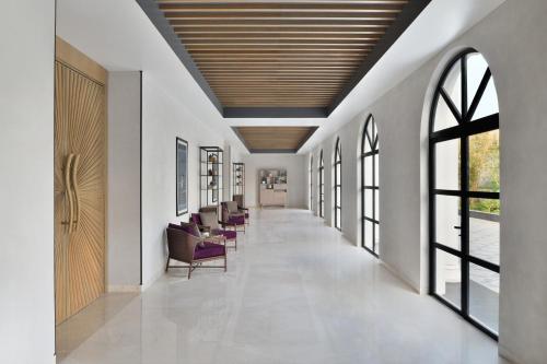 a corridor of a hospital with chairs and windows at Port Muziris, A Tribute Portfolio Hotel by Marriott in Nedumbassery
