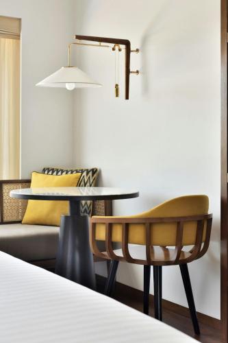 a dining room with a table and a couch at Port Muziris, A Tribute Portfolio Hotel by Marriott in Nedumbassery