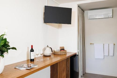 a room with a table with wine glasses and a television at The Richmond Inn in Richmond
