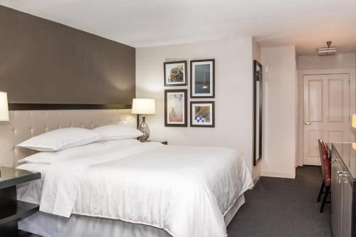 a bedroom with a large white bed and a desk at Sheraton Minneapolis West Hotel in Minnetonka