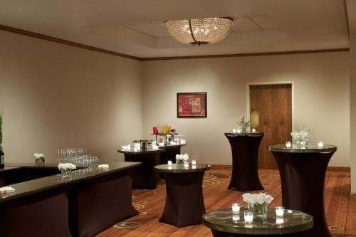 a bar with a row of tables with wine glasses at Sheraton Minneapolis West Hotel in Minnetonka