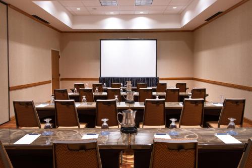a large room with tables and chairs and a projection screen at Sheraton Minneapolis West Hotel in Minnetonka