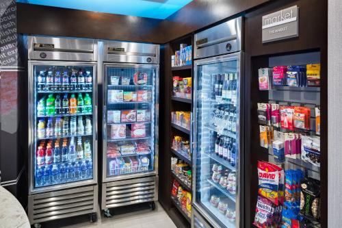 a grocery store aisle with two refrigerators and drinks at SpringHill Suites Milford in Milford