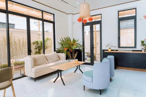 a living room with a couch and chairs at Nami Homestay in HÆ°ng YÃªn
