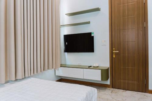 a bedroom with a bed and a flat screen tv at Nami Homestay in HÆ°ng YÃªn