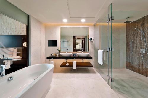 a bathroom with two sinks and a bath tub at Marriott Hotel Al Forsan, Abu Dhabi in Abu Dhabi