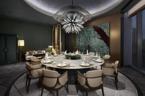 a dining room with a table and chairs and a chandelier at HUALUXE Shenzhen Bao'an in Shenzhen