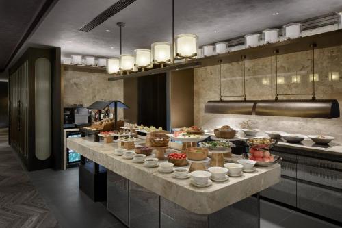a buffet line with food on it in a kitchen at HUALUXE Shenzhen Bao'an in Shenzhen