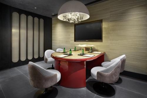 a room with a table and chairs and a tv at HUALUXE Shenzhen Bao'an in Shenzhen