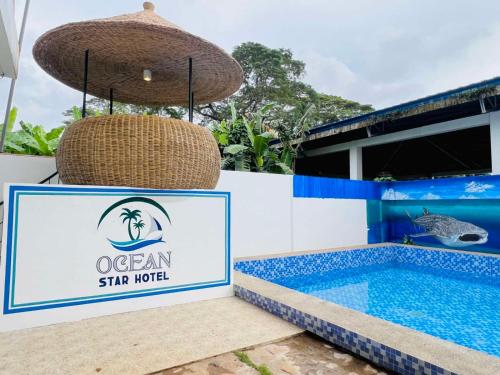a sign for an ocean star hotel next to a swimming pool at Ocean Star Hotel Coron in Coron