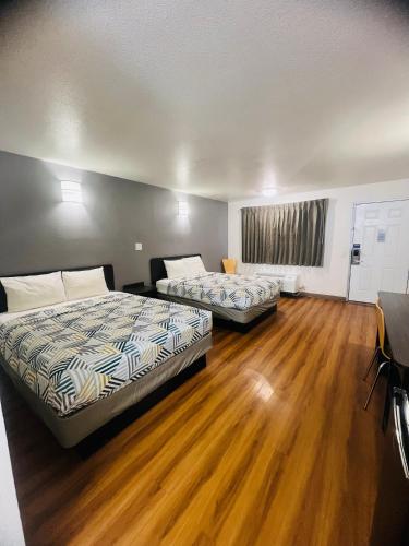 two beds in a room with wooden floors at Motel 6-Brinkley, AR in Brinkley