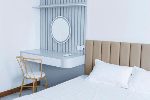 a bedroom with a bed and a mirror and a chair at Nami Homestay in HÆ°ng YÃªn