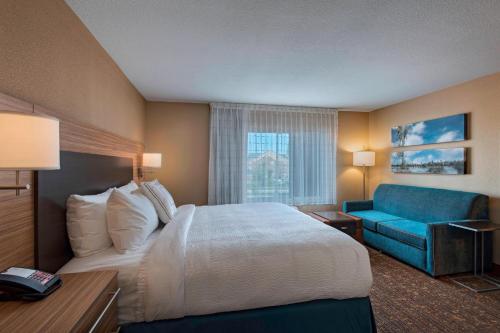 a hotel room with a bed and a blue couch at TownePlace Suites by Marriott Columbia in Columbia