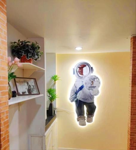 a painting of a astronaut hanging on a wall at Youjia Youth Hostel in Bang Rak