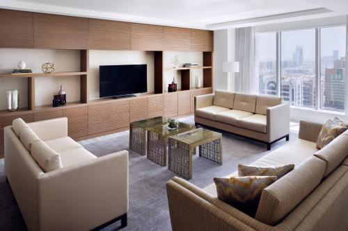 a living room with two couches and a television at Marriott Hotel Downtown Abu Dhabi in Abu Dhabi