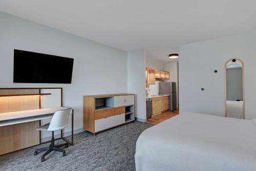 a hotel room with a bed and a desk with a television at TownePlace Suites by Marriott Sumter in Sumter