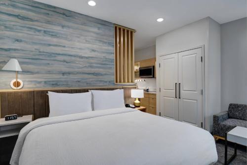 a bedroom with a large bed and a chair at TownePlace Suites by Marriott Sumter in Sumter