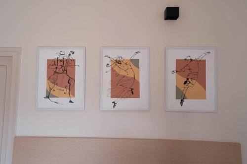 four framed pictures on a white wall at The Lavish Affair in Bhuj