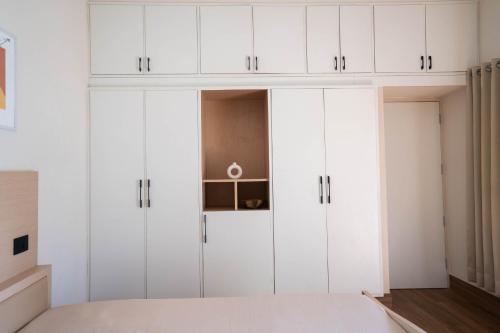 a bedroom with white cabinets and a bed at The Lavish Affair in Bhuj