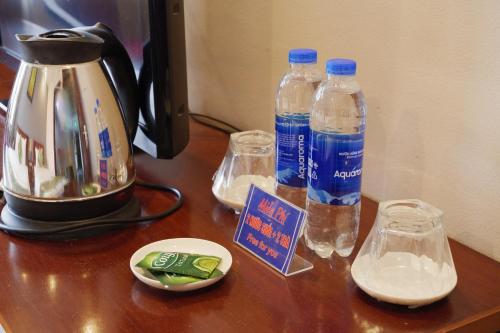 a tea kettle and two bottles of water on a table at Ngan Ha Hotel Long Bien in Hanoi
