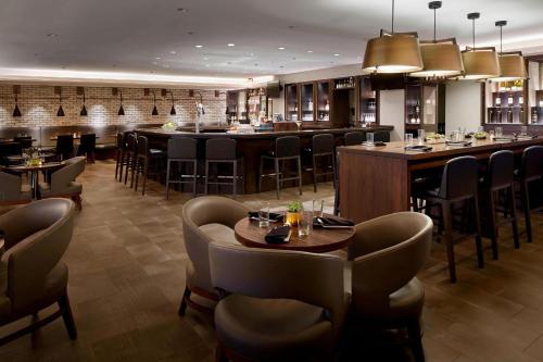 a restaurant with tables and chairs and a bar at Marriott Hartford/Windsor Airport in Windsor
