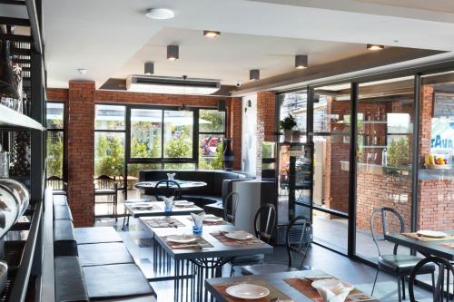 a restaurant with tables and chairs and windows at Mazi Design Hotel by Kalima in Patong Beach